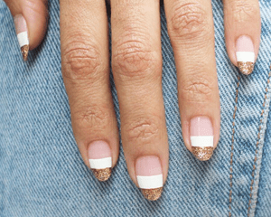 gold and white block stripe nail design against denim background